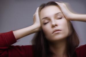 Picture of a woman closing her eyes and putting her hands on both sides of her head.