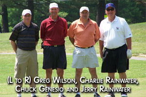 Picture of four male golfers outside on a golf course. (L to R) Greg Wilson, Jerry Rainwater, Chuck Genesio, and Jerry Rainwater