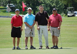 Picture of four male golfers on a golf course. (Vince Hughes, Nick Italiano, Jason Akerman, and Tony Italiano)