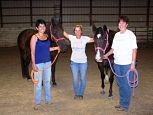 Picture of three females with two horses.