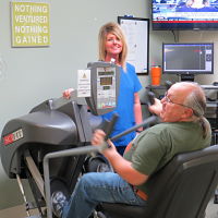 Picture of a female Respiratory Therapist in a room with a male patient in the Cardiopulmonary (Respiratory) Department.